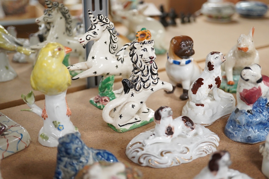 A collection of 19th/20th century Staffordshire and continental porcelain models of animals and birds, including a 20th century Meissen figure of a canary, two Continental porcelain Panthers, two similar recumbent dogs,